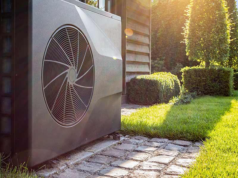 A heat pump unit sat in a building's garden
