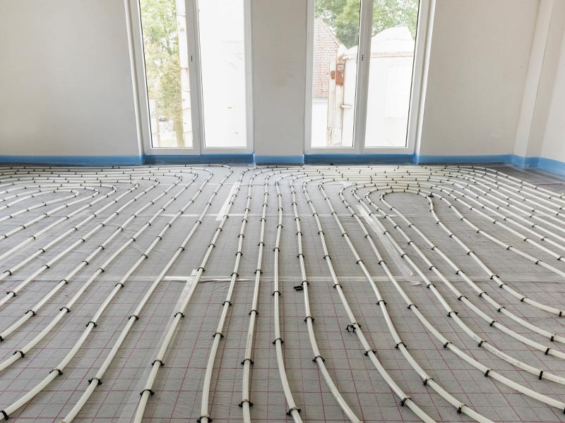 A room with exposed under floor heating pipes all over the floor.